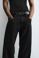 Pantalón de jean gris oscuro, corte amplio, con cinco bolsillos, efecto lavado y cierre frontal con cremallera y botón.