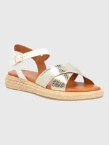 Sandalia de estilo minimalista con tiras metalizadas y textura de piel de serpiente, ajuste con hebilla en el tobillo y base tejida tipo esparto.