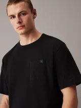 Remera negra de algodón y elastano, con cuello redondo, manga corta y bolsillo en el pecho.