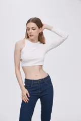 Top blanco de poliéster, corte crop top, con cuello redondo y un hombro cubierto con manga larga. Presenta un corte cut-out en la cintura.