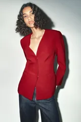 Blazer rojo de escote pico y manga larga. Bolsillos de vivo en delantero. Cierre frontal con botones a presión.