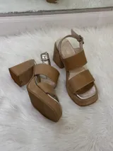 Sandalias de plataforma color beige con tiras anchas y hebilla metálica.