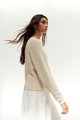 Sweater de punto color crudo, de corte recto y mangas largas.