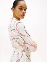 Minivestido cruzado de viscosa color crema con estampado de cadenas en negro y rosa, cuello en V y cinturón anudable.