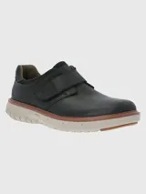 Zapato marrón de cuero con ajuste de velcro y suela gruesa color crema.
