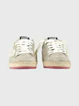 Championes Golden Goose BallStar de gamuza color gris con estrella dorada en el lateral, cordones blancos y suela con detalles en rojo.