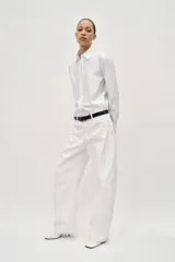 Camisa blanca de popelina de algodón, con cuello solapa y mangas largas con puños abotonados.