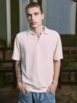 Polo de manga corta color crema, con cuello tipo polo y corte relajado.