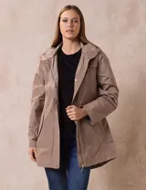 Campera impermeable color beige, marca Weatherproof, con capucha desmontable, cierre central oculto con botones a presión, bolsillos laterales con cierre y corte a la altura de la cadera.