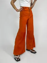 Pantalón de cuero color naranja, de corte ancho y tiro medio alto.