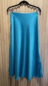 Falda midi de raso color celeste, corte evasé con elástico en la cintura.