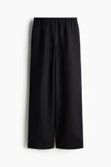 Pantalón negro de lino, corte ancho, con cintura elástica y cordón ajustable.