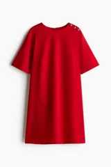 Vestido corto rojo con cuello redondo y manga corta. Presenta detalle de botones dorados en el hombro.