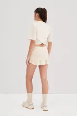 Minifalda color crema con short interno y tres volados horizontales.