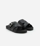 Sandalia slide city negra de material sintético, con tiras cruzadas y hebilla ajustable.