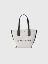 Bolso shopper Longchamp modelo Le Roseau XS, color crudo con detalles en cuero negro. Tiene doble asa corta, cierre con broche a presión y logo estampado en el frente.