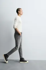 Pantalón de jean color beige, corte skinny, tiro medio, largo cropped y cinco bolsillos.
