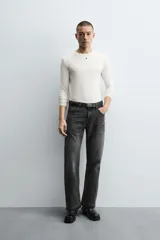 Pantalón de jean celeste de corte flare, con tiro medio, cinco bolsillos, cierre frontal con cremallera y botón, y bajo con acabado irregular.