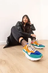 Zapatillas deportivas color mostaza con detalles en beige, verde y blanco.