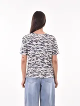 Remera de manga corta con estampado abstracto en tonos beige, negro y blanco.