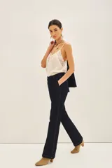 Pantalón sastrero de denim azul oscuro, corte recto, con costuras a contratono, cierre metálico, gancho sastrero y botón en la cintura.
