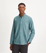 Camisa blanca de algodón, manga larga con botonadura frontal y cuello camisero.