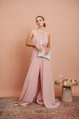 Mono de fiesta color rosa pálido, con cuello halter, cuerpo drapeado con lentejuelas y pantalón palazzo. Incluye cinturón con lentejuelas.