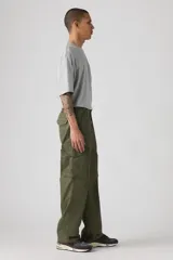 Pantalón cargo verde militar, de corte holgado, con bolsillos laterales con solapa y bolsillos traseros.