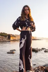 Pantalón palazzo negro con cintura elástica y estampado de sirenas blancas.