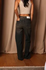 Pantalón de jean de tiro alto con lavado oscuro y detalles de desgaste.