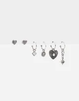 Set de aros plateados con dijes de corazón, sol, estrella y piedra. Incluye aros tipo botón con diseño de corazón.