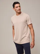 Remera beige de piqué con cuello redondo y logo bordado en blanco.