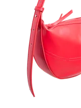 Bolso de hombro efecto cuero color rojo vibrante, con forma curva y cierre de cremallera. Presenta costuras decorativas y herrajes plateados.