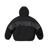 Campera reversible negra con capucha, de algodón y piel sintética. Presenta un bolsillo tipo canguro en el frente y el logo de Supreme bordado en la espalda.