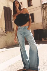 Top negro de organza con cuello halter, tirantes finos y detalle de maxi flor con volumen.