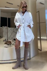 Vestido camisero blanco de algodón, corte holgado, con botones de madera, cuello clásico y lazo en la cintura.