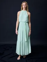 Vestido largo de gasa color verde menta, marca Julia Jordan. Tiene escote halter, cintura elastizada con lazo de ajuste y abertura central en la espalda con botones.