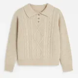 Sweater color beige tejido en lana simil cashmere, con cuello polo y cartera abotonada.