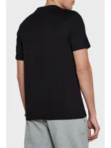 Remera negra de algodón regenerativo con cuello redondo, dos rayas horizontales blancas en el pecho, logo monotipo de Tommy Hilfiger en el pecho y bandera de Tommy Hilfiger bordada en la manga.