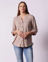 Blusa blanca texturizada marca Ninety, con cuello a la base, escote en V, abertura central con botones, bolsillo delantero y mangas tres cuartos regulables con presilla y botón.