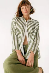 Camisa celeste y blanca a rayas verticales, de corte holgado y mangas largas.