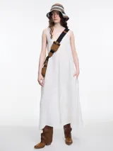 Vestido largo blanco de lino 100% con escote en V y tajo delantero. Diseño con costura central y bordado tipo pespunte en color contraste.