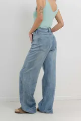 Pantalón de jean azul de tiro alto y corte wide leg, con detalle de parche animal print en la parte trasera.