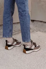 Championes de cuero color marrón, negro y beige, con cordones negros y suela blanca.