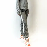 Pantalón de jogging gris con interior afelpado y raya blanca a los costados.