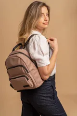 Mochila funcional color beige con detalles en negro, que incluye dos compartimentos con cierre y un bolsillo frontal para fácil acceso.