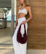 Bolso hobo color crema con tachas plateadas y cierre con botón magnético.