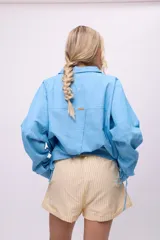 Short de algodón y lino a rayas verticales amarillas y blancas, con cintura elástica y cordón ajustable.