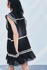 Minivestido negro de algodón con bordados florales blancos en cuello, mangas y ruedo.
