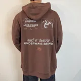 Canguro marrón con capucha y corte oversize. Estampa en la espalda con diseño de pulpo y texto en blanco y naranja.